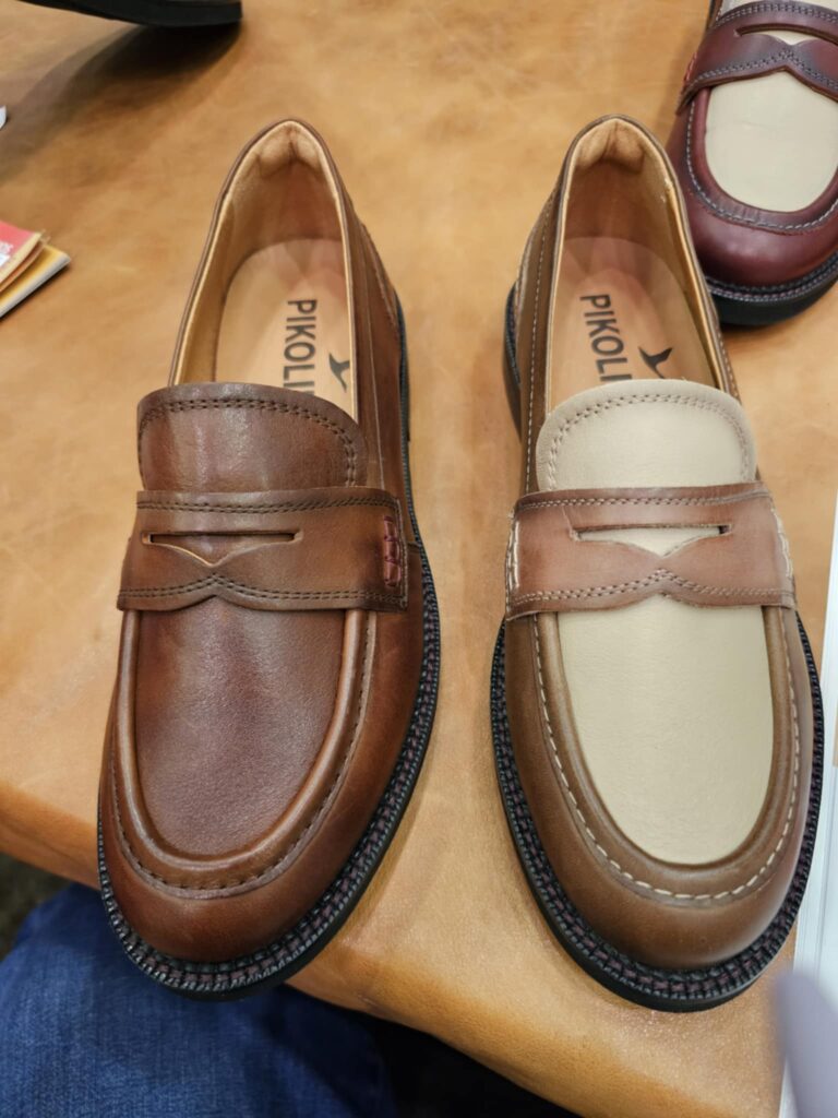 Two leather loafers in brown and tan displayed side by side on wooden table. | Rogue Sole & Style