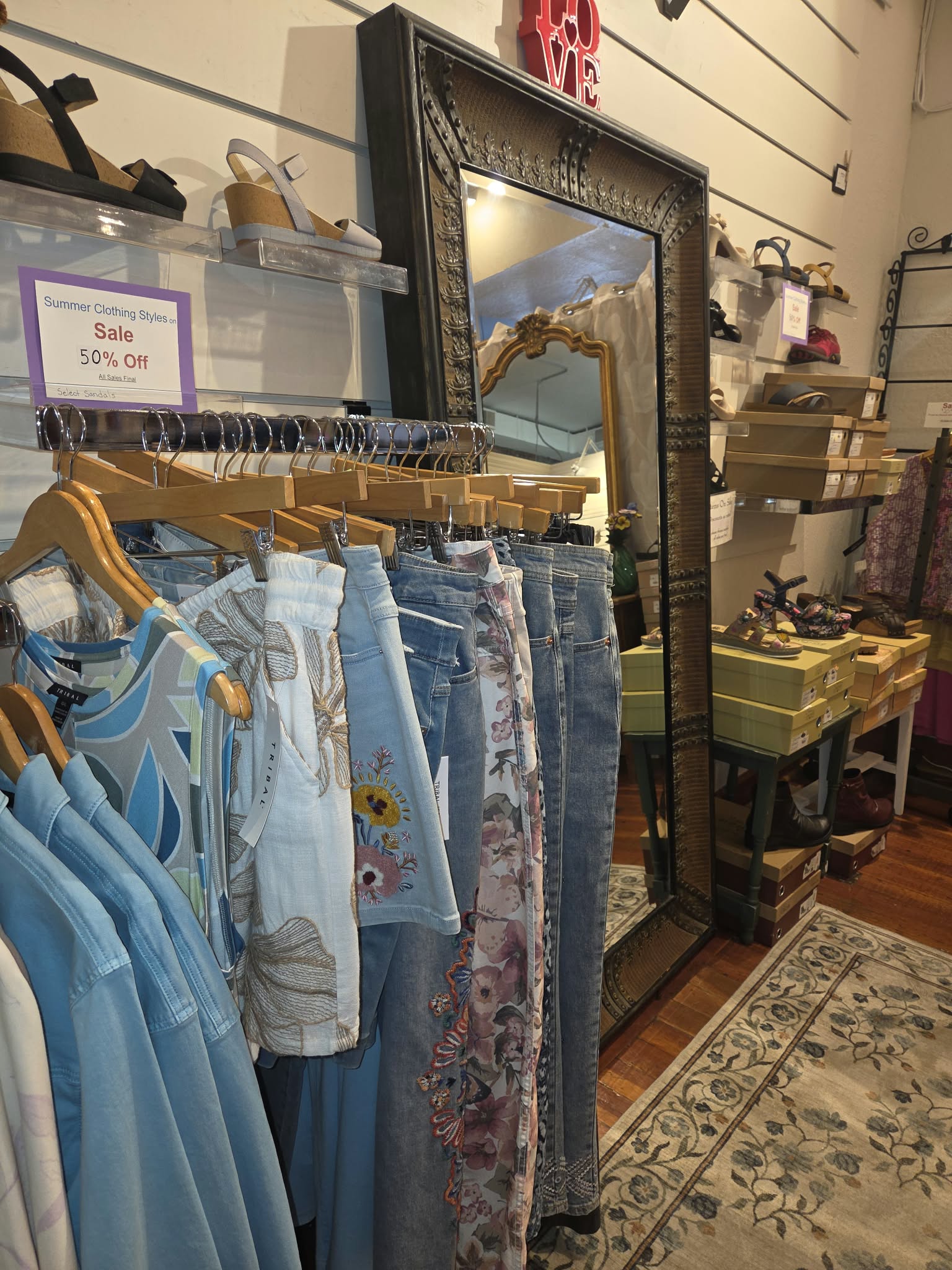 Women's tops, embroidered denim and patterned clothing on a rack at Rogue Sole & Style in Grants Pass